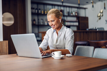 Fototapeta premium A businesswoman typing on laptop in cafe.