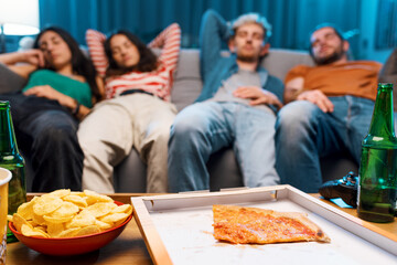 Friends sleeping on the couch after eating pizza