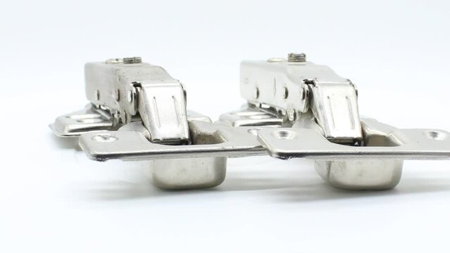 Hydraulic cabinet hinge on white background with selective focus