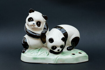 Vintage porcelain figurine - pair of panda bears isolated on black background