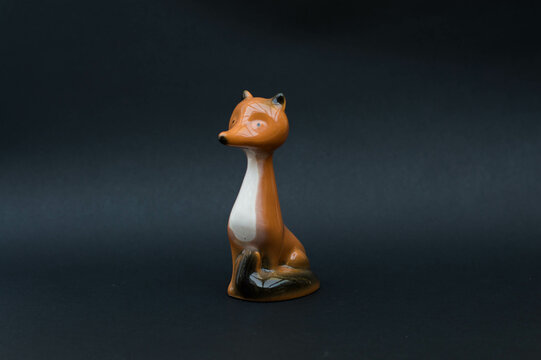 Vintage porcelain figurine - fox isolated on black background