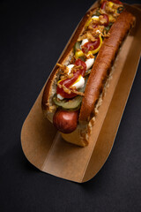 Hot dogs in paper plates with sausages and sauce 
