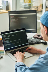 Close-up of young female programmer creating online apps on laptop while working at workplace at...