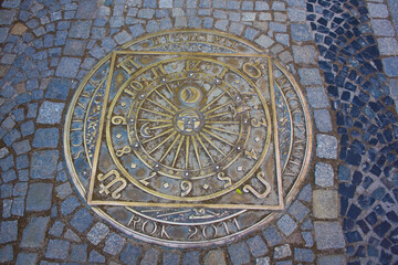 Beautiful manhole bronze cover with symbols of zodiac in Wroclaw