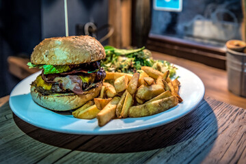 Tasty burger with bacon and french fries