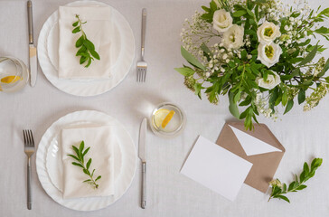Wedding teble decoration with white flowers, glasses and white napkins. Elegantly decorated table at a wedding reception. Festive table setting. The wedding decor.