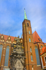 Fototapeta na wymiar Statue St John of Nepomuk and Church of the Holy Cross in Wroclaw 