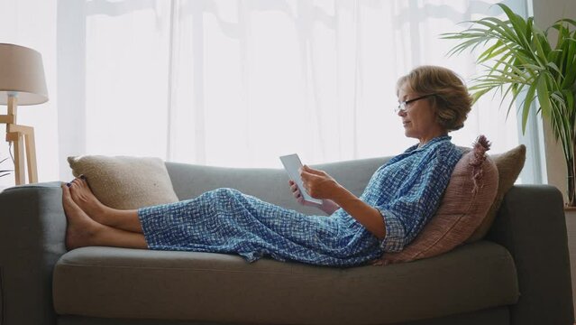 Cinematic storytelling footage of a beautiful senior woman spending time in her cozy apartment, doing daily lifestyle activities. 