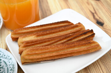 Assiette de churros et verre de jus d'orange