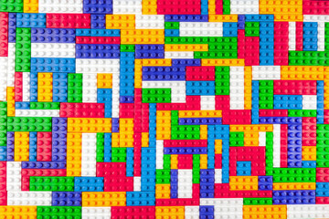 Abstract background texture of colored constructor blocks. Background of colorful plastic part of constructor. Pile of colored toy bricks.
