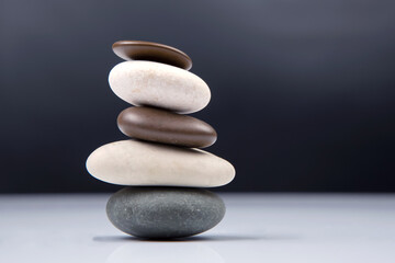 pyramid of stacked stones on a dark background. stabilization and balance in life