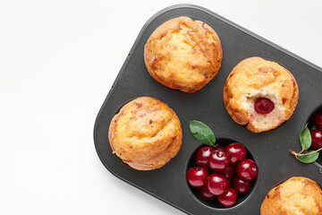 Vanilla muffin with sweet cherries, decorated by berries isolated on white background.   