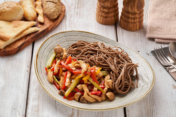 Asian soba noodles with stewed chicken breast with wegetables. Oriental dishes.