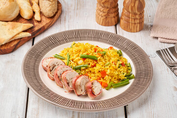 Grilled bites of chicken rolled in bacon served with fried rice with vegetables. Concept of healthy food.