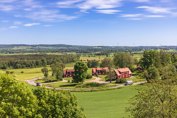 Rural landscape view with red houses by a road with cars