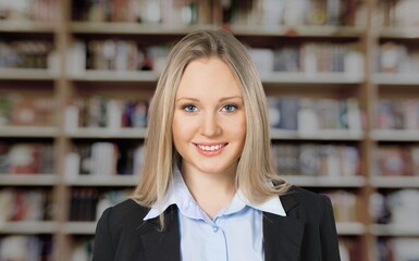 A young beautiful teenager girl smile looking at camera in university library, concept of higher...