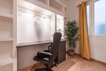 black wooden study table with drawers and glass shelves with plaster work shelves and swivel black leather chair