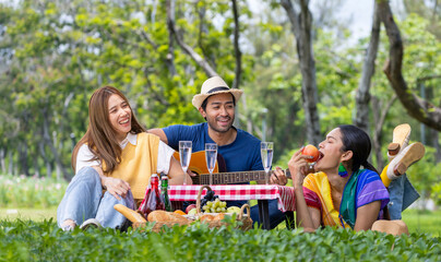 Group of young diversity close friend having a picnic in the garden while enjoy singing music in...