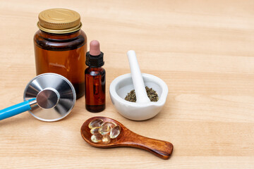 Alternative medicine, naturo path and dietary supplement. Herbal remedy in capsules and plants over wooden background.