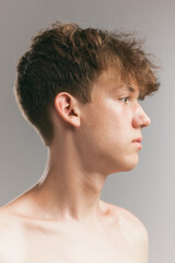 Fototapeta na wymiar Closeup young man, teen isolated on grey studio background. Concept of teenage skin care, health, cosmetics for problem skin, youth