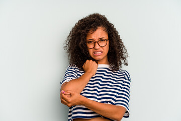 Young Brazilian woman isolated on blue background massaging elbow, suffering after a bad movement.