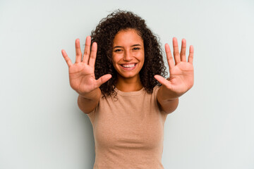 Young Brazilian woman isolated on blue background showing number ten with hands.