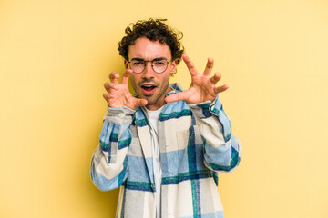 Young caucasian man isolated on yellow background upset screaming with tense hands.