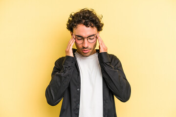 Young caucasian man isolated on yellow background having a head ache, touching front of the face.