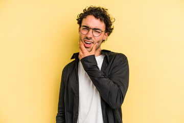 Young caucasian man isolated on yellow background having a strong teeth pain, molar ache.