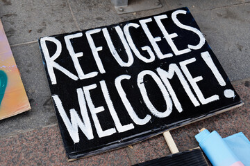 Sign written Welcome refugees. Accept people on the move. Help the migrants. Human rights. Protest...