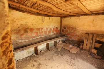 Inside of barn with dirty wood and broken bench