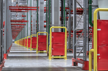 Lifting equipment with cargo near high shelving in storage