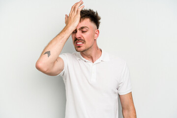 Young caucasian man isolated on white background forgetting something, slapping forehead with palm and closing eyes.