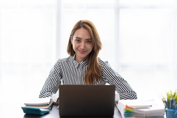 Portrait of businesswoman working with computer laptop on the table in modern meeting room.