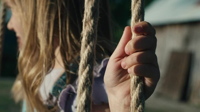 Close up of little girl swinging in summer day. Shot with RED helium camera in 4K.   