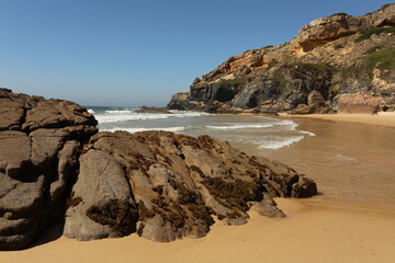 Fototapeta na wymiar Hidden beach by the ocean sea with natural caves and sand