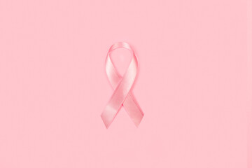 Lazo cinta rosa de concientización sobre el cáncer de mama sobre un fondo rosa pastel liso y aislado. Vista superior y de cerca. Copy space - obrazy, fototapety, plakaty