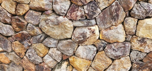 Arrange stones of different sizes and colors in an orderly manner. for a strong and beautiful stone wall part of a stone wall for background or texture
