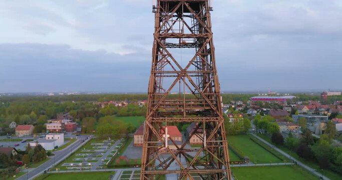 Aerial view of the wooden broadcasting tower in Gliwice with the city of Gliwice in the background. The concept of the largest wooden tower in the world. Wooden construction from a drone.