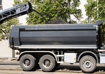 Road scraper machinery and a truck at the road construction