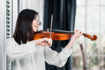Portrait of a Asian female violinist who is playing a string instrument