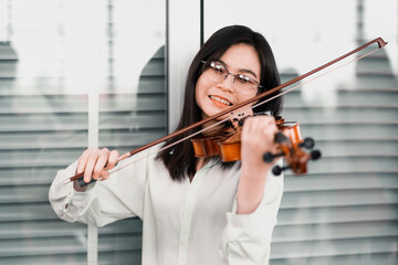 Portrait of a Asian female violinist who is playing a string instrument