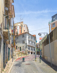 Fototapeta premium An old street in Alfama in a summer sunny day. Lisbon, Portugal