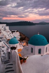Gorgeous vertical shot of the village of Oia in Santorini, Greece under pink clouds at sunset