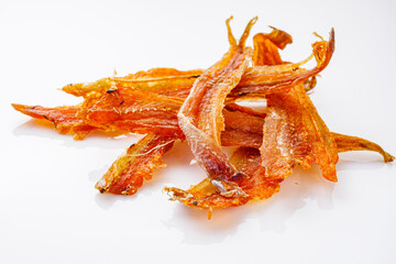 dried fish beer snack on a white acrylic background