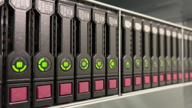 HDD SATA Server. LED lamps blink in data server with multiple hard drives in big rack.