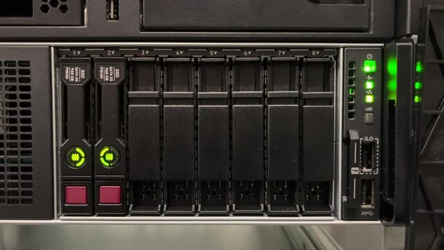 HDD SATA Server. LED lamps blink in data server with multiple hard drives in big rack.