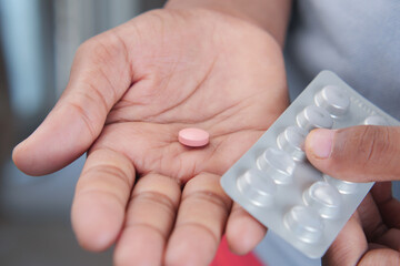 Close up of hand holding blister packs .