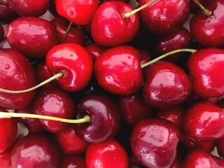 Stock photo of ripe juicy cherries in bright wine color. Macro photography of fresh tasty berry, top view of a whole basket of sour and sweet berries, fruits for background, design, patterns, print