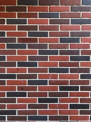 Bright stock photo of a red-orange and blue brick false facade. Close-up photo of fake brickwork on the facade of a building. For background, texture, print, design